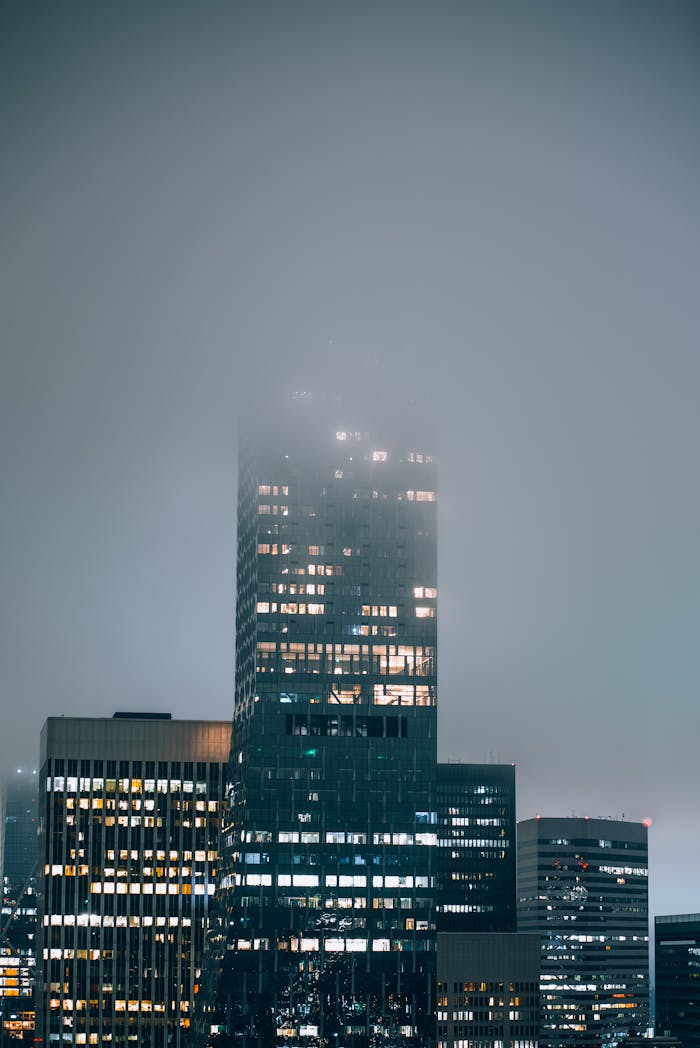 Urban skyline of Seattle, with skyscrapers enveloped in thick fog at night.
