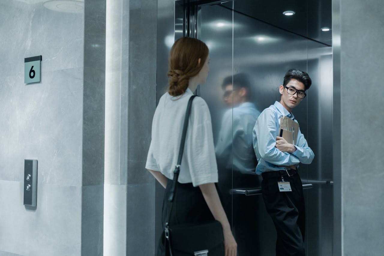 creative Office colleagues meeting in an elevator, showcasing a professional setting.